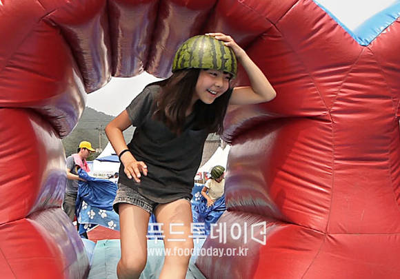 수박모자쓰고 장애물 넘기 경기 중인 어린이
